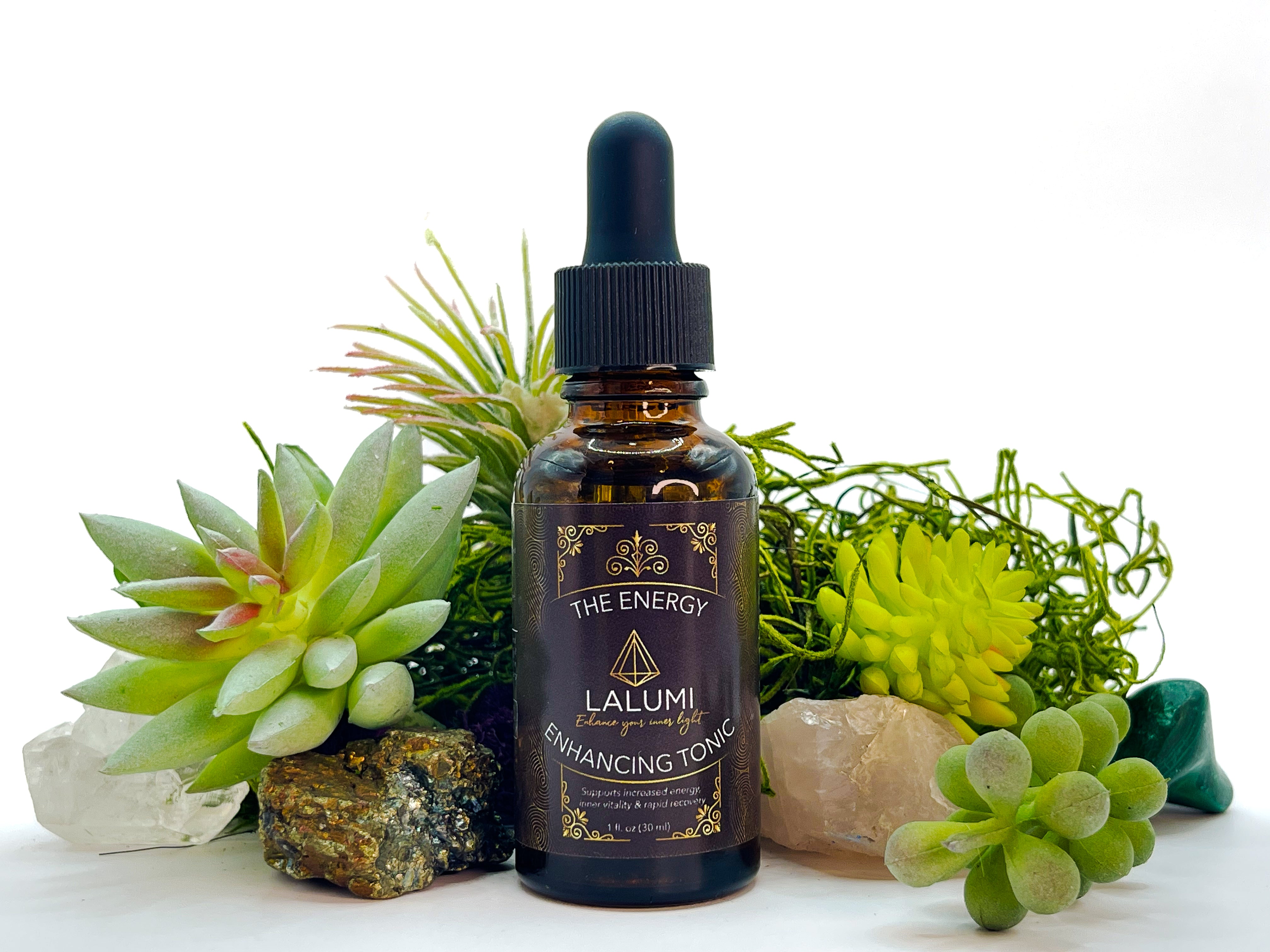 Image of 1 oz bottle of Energy-Enhancing Herbal Tonic by LaLumi Herbes with decorative plants and crystals on a white background