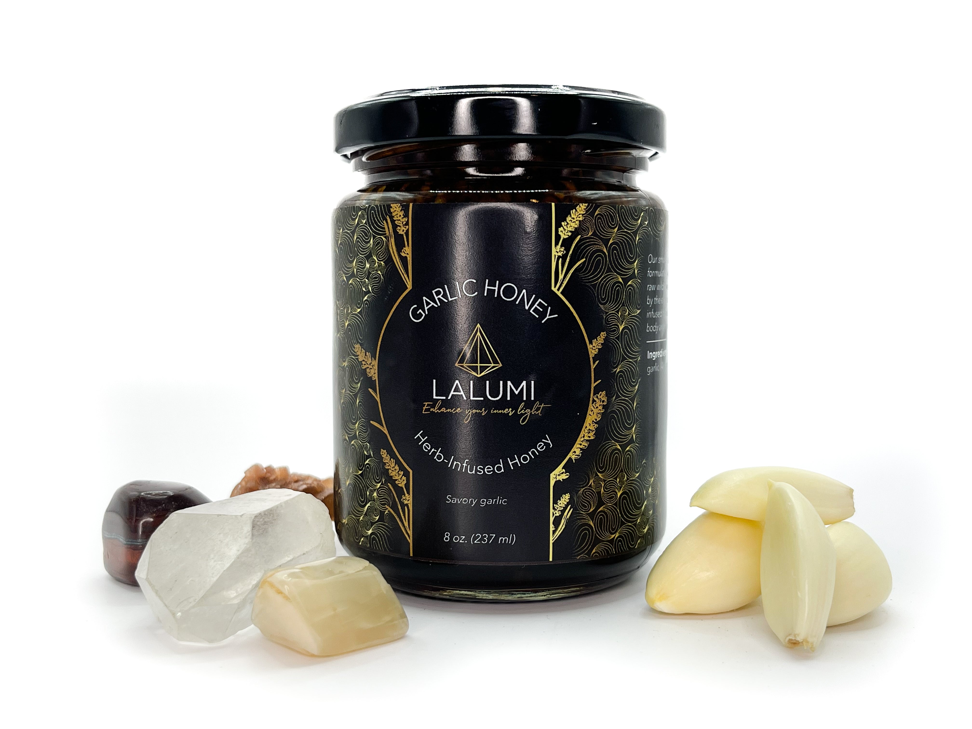 Image of 8 oz jar of Organic Garlic Infused Local Honey by LaLumi Herbes with garlic cloves and honeycomb on a white background