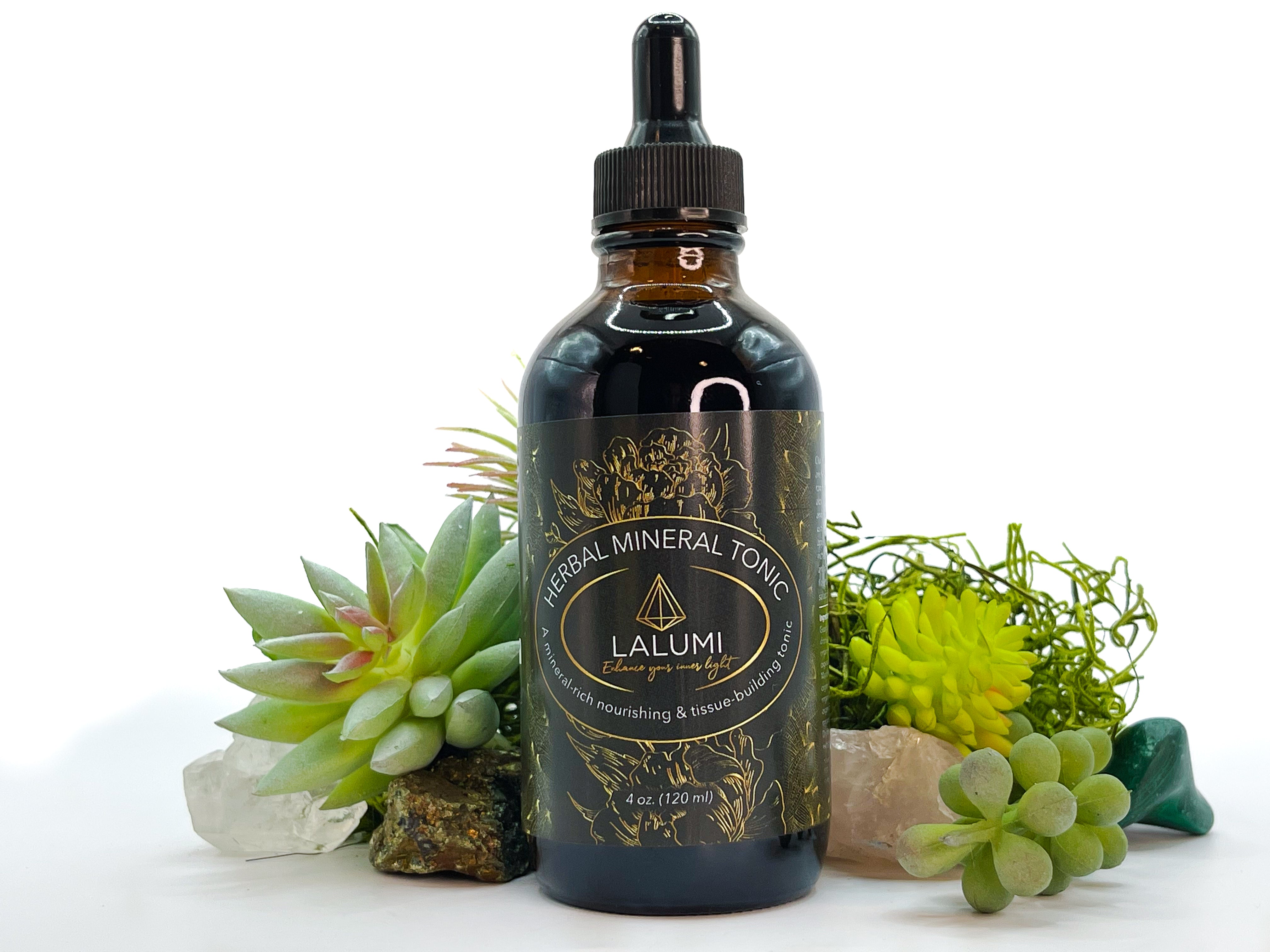 Image of 4 oz bottle of Herbal Mineral Tonic by LaLumi Herbes with succulents and crystals on a white background